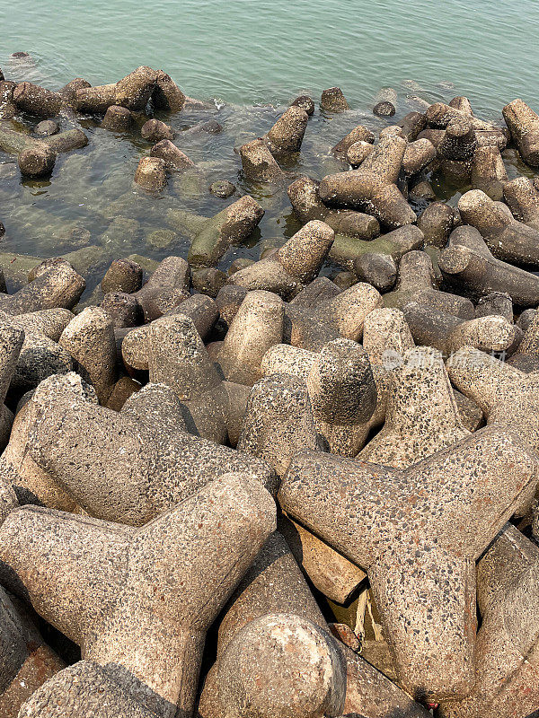 印度孟买的Marine Drive海堤特写图像，环环相扣，混凝土，四足块海防，海岸管理，防止侵蚀，海水和海浪，高架视图，重点放在前景上